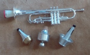 Труба с обычной картонной сурдиной, внизу (слева направо):
металлическая «груша», джазовая сурдина для эффекта «уа-уа»,
сурдина «грибок».